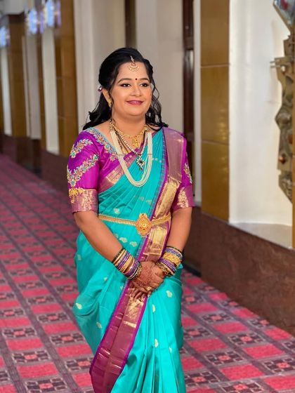 A full-length view of Swathi's reception attire. The simple gold jewellery and elegant hairstyle create a look of understated grace.