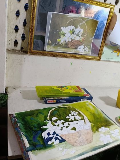 A watercolor still life of a basket of flowers in progress. This image captures the initial washes of color being laid down.