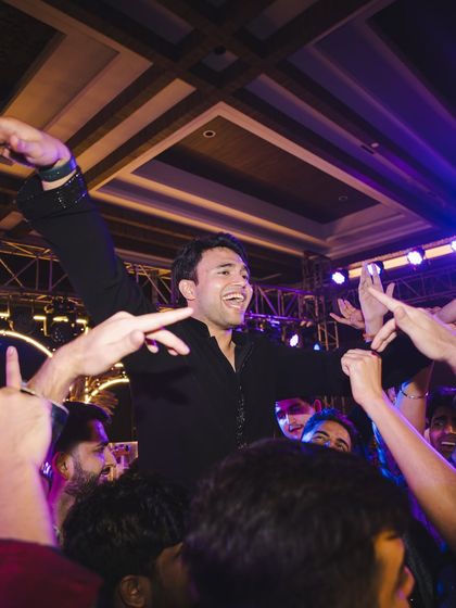 The moment the groom is lifted by his friends in celebration after a fantastic sangeet performance. Pure joy.