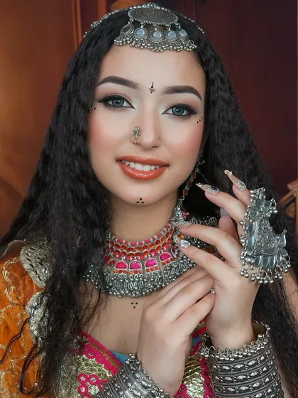 This pose highlights the hand jewelry and nail art, reminding that a complete look involves attention to every detail, a key lesson in our professional courses.