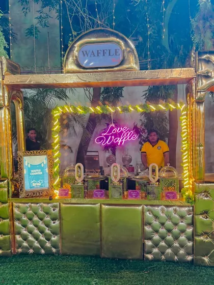 A full view of the grand, green and gold waffle counter, ready for service.