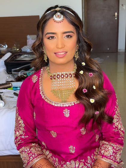 A smiling portrait of the bride, showing how the soft, floral-accented hairstyle enhances her happy glow.
