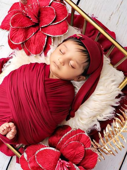 This angle shows the baby wearing an adorable red sleepy cap.