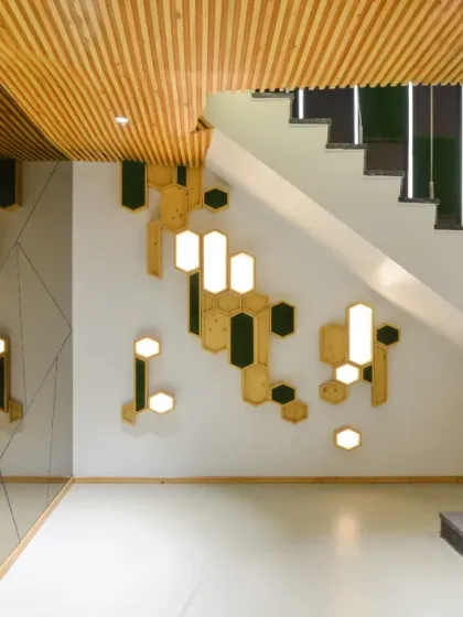 A mirror wall in the AMG office lobby elegantly conceals the space beneath the staircase. The abstract grooves etched into the mirror create an intriguing illusion, adding another layer of visual interest to the design.