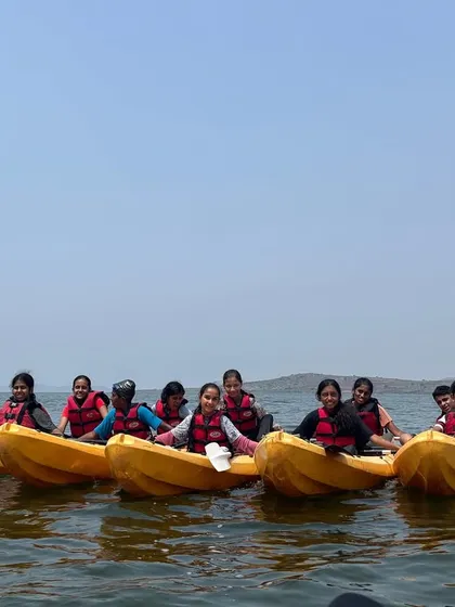 A team of young girls in bright yellow kayaks rafts up for a group photo during a summer camp at Vani Vilas Sagar.