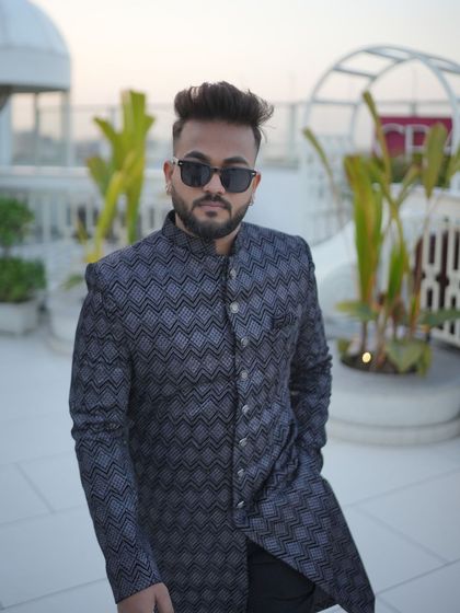 A stylish man in a modern, patterned Indo-Western achkan, showcasing a confident and contemporary look perfect for a festive evening or a friend's wedding.
