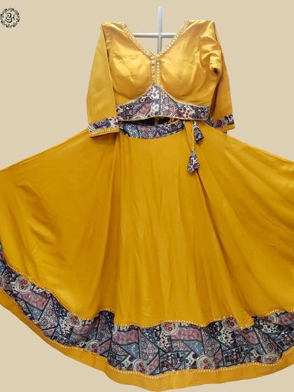 A stunning yellow lehenga for the fifth day of Navratri. The solid yellow skirt is beautifully contrasted with a printed border and a matching blouse, creating a look that is both elegant and festive.