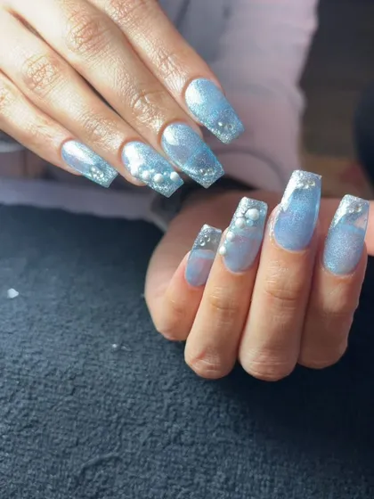 A dreamy, "cinderella" blue set of long, square nails with a glittery finish and 3D pearl "bubble" accents.