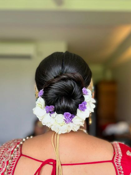 A simple yet stunning floral bun using white and purple flowers. This is a great example of how a few well-placed flowers can create an elegant statement.