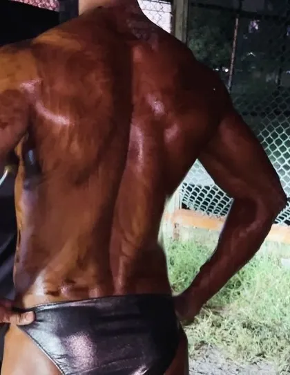 The final moments before hitting the stage. Applying the perfect competition tan is crucial for showcasing muscle definition under the bright lights. I guide my athletes on this as well.