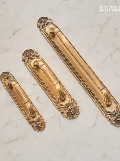 These main door handles from the Mumtaz Collection feature a substantial backplate with ornate, classical detailing. They are designed to create a grand and impressive entrance.
