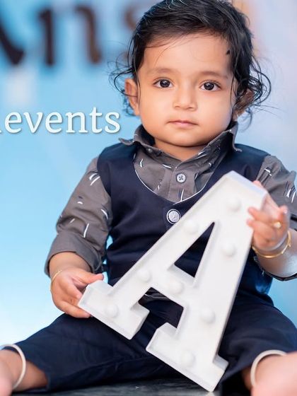 A professional shot of the birthday boy with his initial, matching the Boss Baby theme.