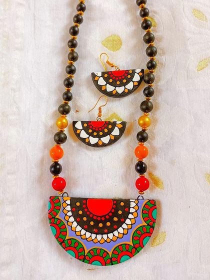 This necklace features a semi-circular pendant with a multi-color mandala design. It's a sleek and artistic piece, perfect for adding a splash of color.