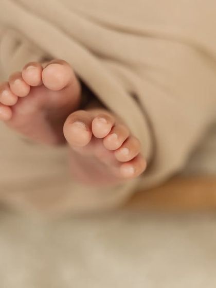 A simple, artistic shot of a newborn's feet peeking out from their swaddle.