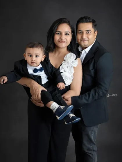 A playful and stylish family portrait. I love how the mom is holding her little boy, who is looking so cute in his formal suit.