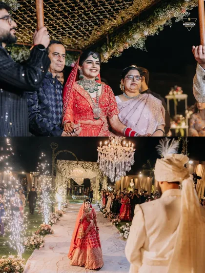 The bride's grand entrance, walking down an aisle lined with sparklers towards her waiting groom. This shot captures the scale and excitement of a big Indian wedding.