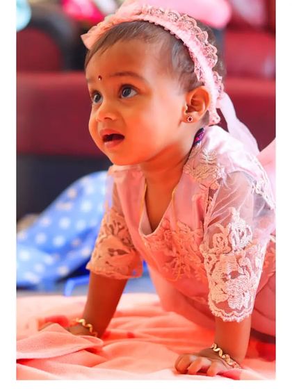 Capturing a milestone moment as this baby girl crawls during her photoshoot. Her determined expression and the soft lighting make for a beautiful action shot.