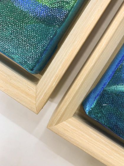 A close-up of the corners of two floater frames, showing the clean joinery and the space between the canvas and the frame that defines this style.