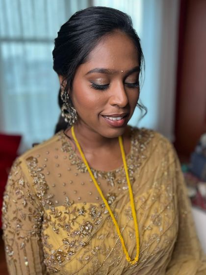 The final look for Anukraha's reception. The glowing base, soft gold smokey eye, and chic messy pony come together for an effortlessly glamorous style.