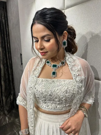 A chic messy ponytail for a modern reception look. The soft texture and face-framing pieces make it effortlessly stylish.