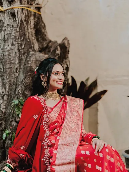 A quiet, elegant portrait. The bride's entire look, from her red saree to her soft makeup, comes together to create a picture of grace and beauty.