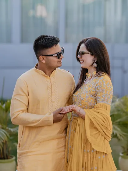 A sweet portrait of the couple during their Haldi ceremony, dressed in matching yellow outfits and sharing a happy, relaxed moment together.