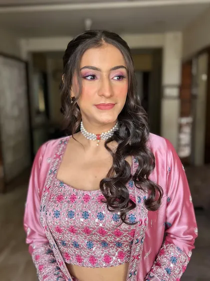 This side profile shows how the makeup and hair work together. The soft curls frame her face beautifully, highlighting the glowing makeup.
