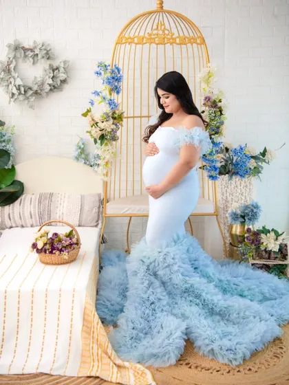 A full view of the light blue ruffled gown, showing how the train spreads out to create a cloud-like effect. It's a perfect choice for creating magical, fairy-tale portraits.