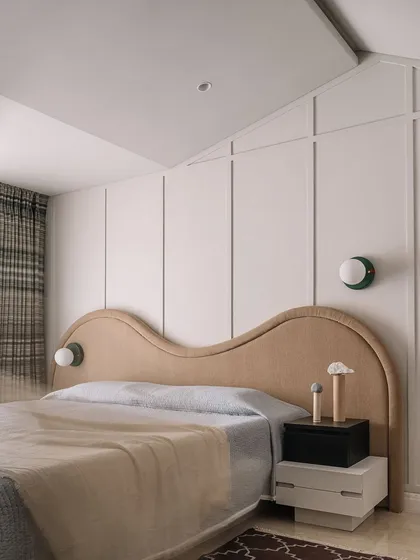 The guest bedroom features a unique, wave-like headboard and a playful, angled ceiling. We love to blur the lines between art and functionality.