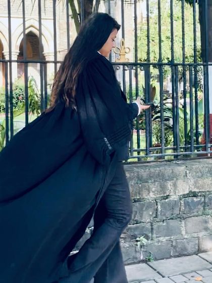 A dynamic shot of me walking past the gates of the Bombay High Court. I am here to conquer challenges and win cases for my clients.