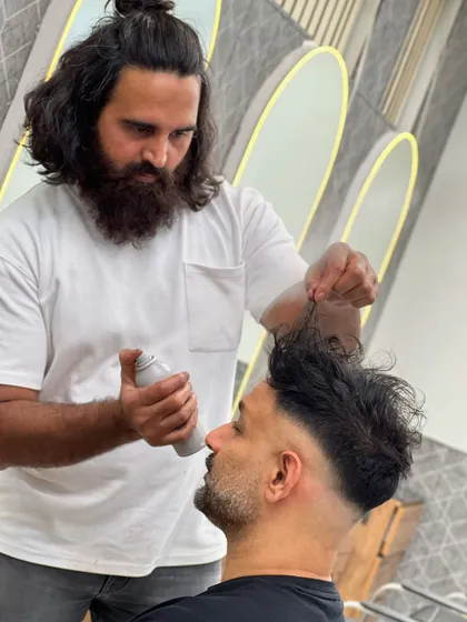 Here I am adding the finishing touches with some styling spray to hold this textured skin fade in place. This technique adds volume and ensures the look lasts all day.