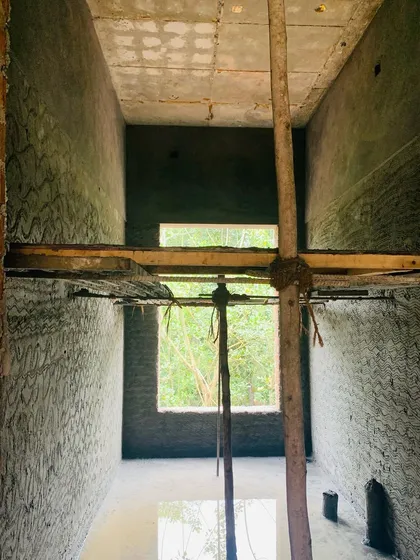 A view through a double-height space during construction, showing how window openings are strategically placed to frame views of the forest. Even at this early stage, the connection between the interior and the natural world is a primary focus.