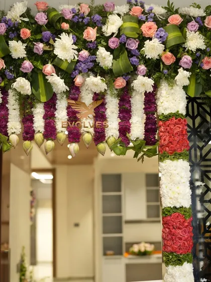 A close-up of the intricate flower work on the housewarming door decor, featuring a mix of roses, carnations, and traditional elements.