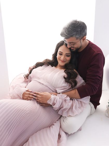 Wrapped in love. This cozy and intimate shot captures the couple sharing a quiet moment, her beautiful pink gown pooling around them.