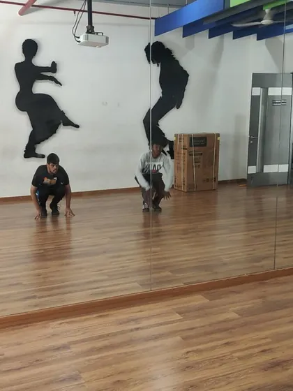 Practicing foundational hip-hop stances and grooves in front of the mirror at IIITB. Repetition is key to building muscle memory and clean technique.