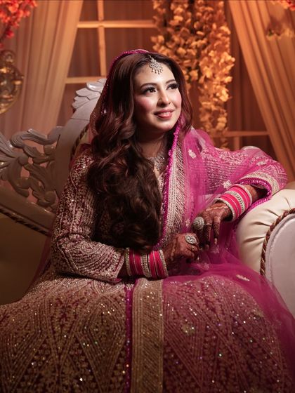 A beautiful portrait of a Walima bride in a stunning pink and gold lehenga. Her makeup is soft and radiant, perfect for the reception festivities.