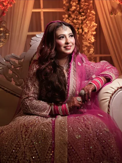 A beautiful portrait of a Walima bride in a stunning pink and gold lehenga. Her makeup is soft and radiant, perfect for the reception festivities.