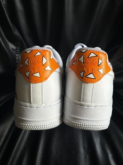 The heel view of a custom Nike Air Force 1 featuring the distinct orange and white triangle pattern of Zenitsu's haori from Demon Slayer.