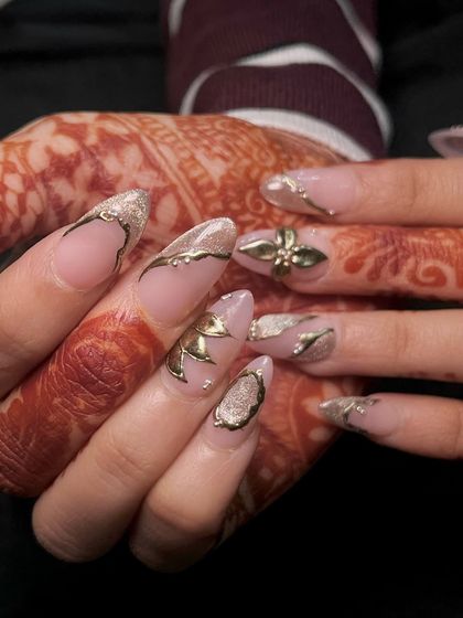 Dripping in gold. This stunning bridal set features intricate gold chrome art and 3D floral accents over a sheer pink base, perfectly complementing the henna.