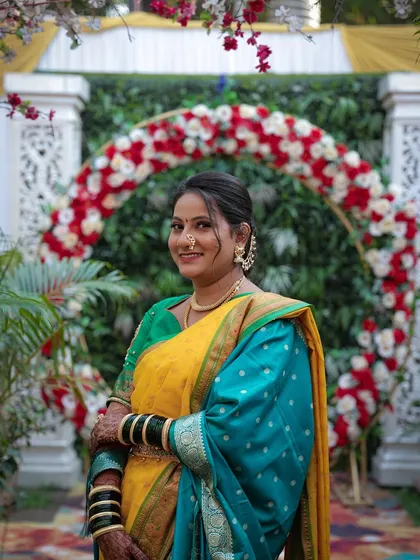 A beautiful portrait of a bride for her Punyawachan look. The yellow and green saree is a classic choice, and her makeup is fresh and radiant.