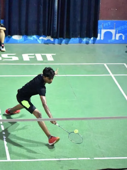 A young player with immense patience and determination, preparing to return a shot at the net.