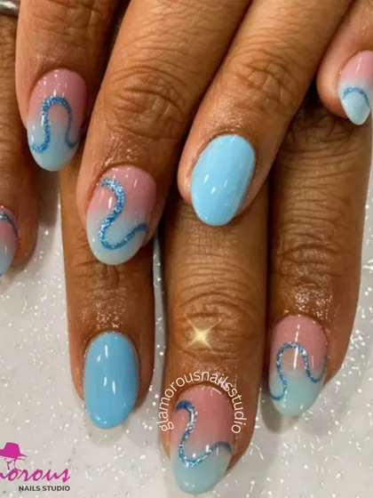 A dreamy pastel design with a blue and pink ombré base, adorned with a sparkling blue glitter swirl.