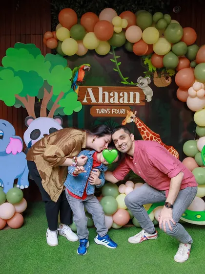 A loving family moment captured at our jungle safari party. The detailed backdrop with multiple animals creates a vibrant and exciting setting for photos.