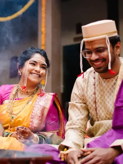 The bride and groom share a laugh by the sacred fire, a candid moment of happiness amidst the solemnity of the wedding ceremony.