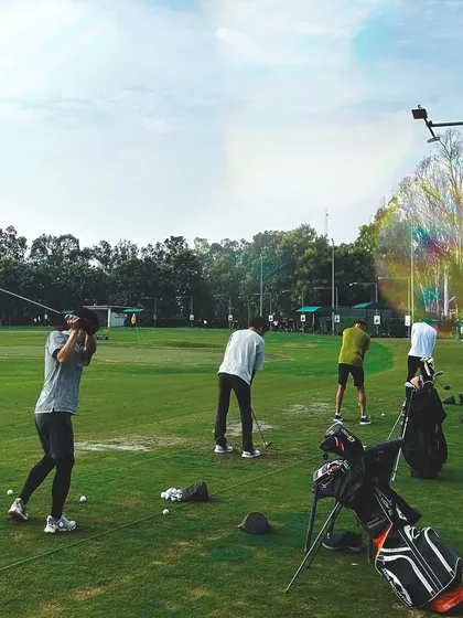 A beautiful shot of the range with a lens flare, capturing the dynamic motion of a full swing.