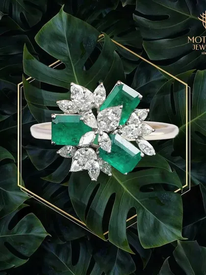 Nature's beauty is captured in this striking ring, where vibrant emeralds are juxtaposed with marquise and pear-shaped diamonds. It is a piece of wearable art for the discerning collector.