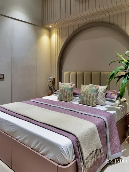 Soft minimalism with a touch of color. This bedroom features a beautiful arched alcove and fluted wall panels, with pops of mauve and dusty pink in the bedding to add warmth and personality to the neutral space.