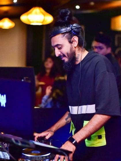 Another angle of me focused on the decks, with my laptop screen glowing in the background. Every detail matters when crafting a set.