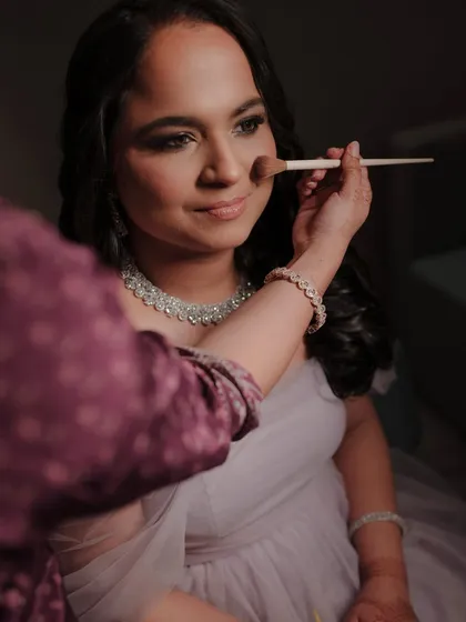 A behind-the-scenes shot of Madhura getting ready for her reception. Here, I'm applying a soft powder to set her classic matte brown smokey eye look.
