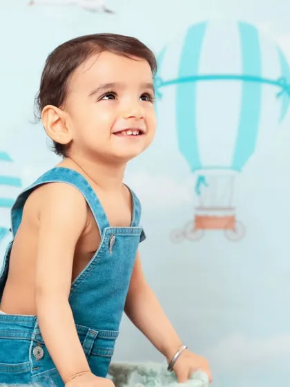 A sweet, upward glance from a baby boy in our hot air balloon setup, as if he's looking at the sky.